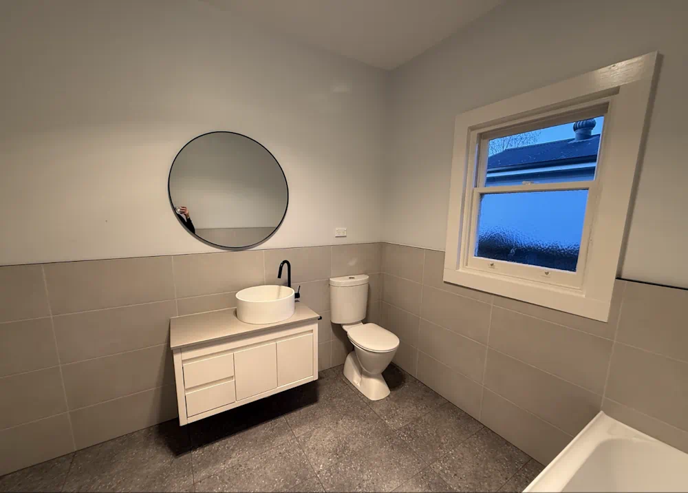 Modern bathroom with round mirror and vanity